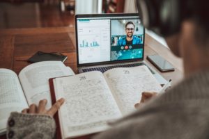 Student watches lecture online while taking notes