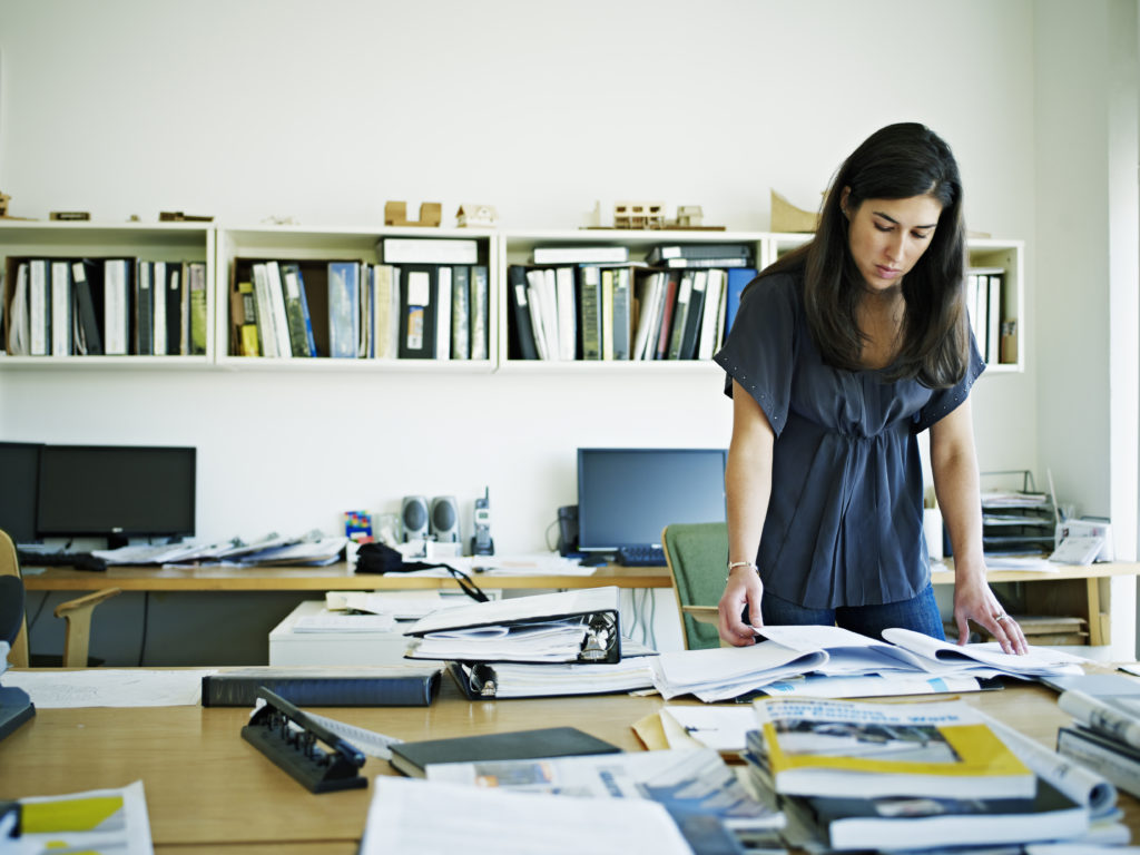 Female faculty examining documents at desk in office