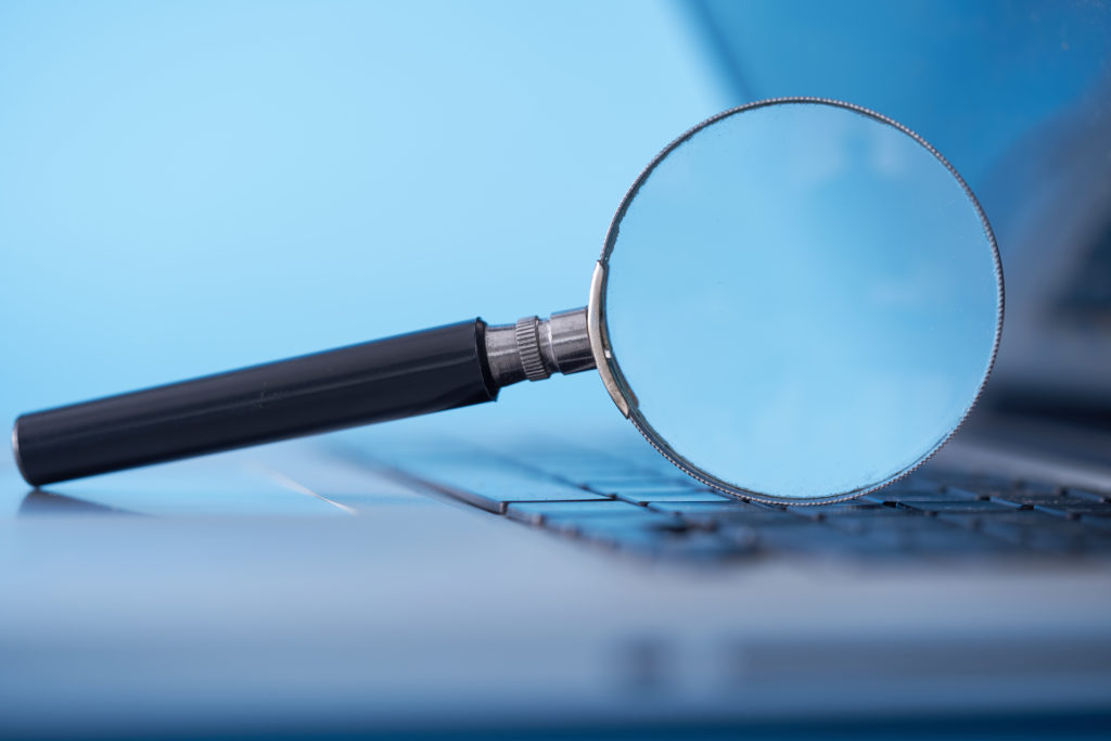 magnifying glass resting on the laptop keyboard