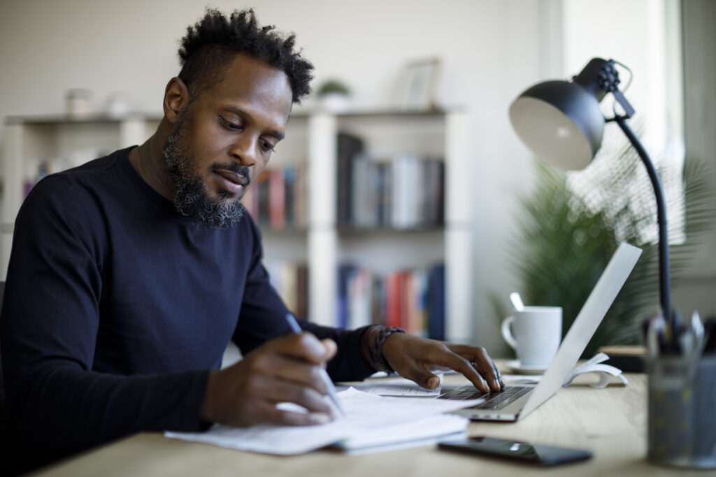 Man completing research at a desk in home office