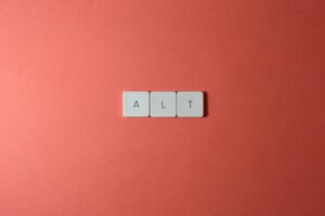 Close-up of ALT keycaps on a coral background, perfect for tech or minimalist themes.