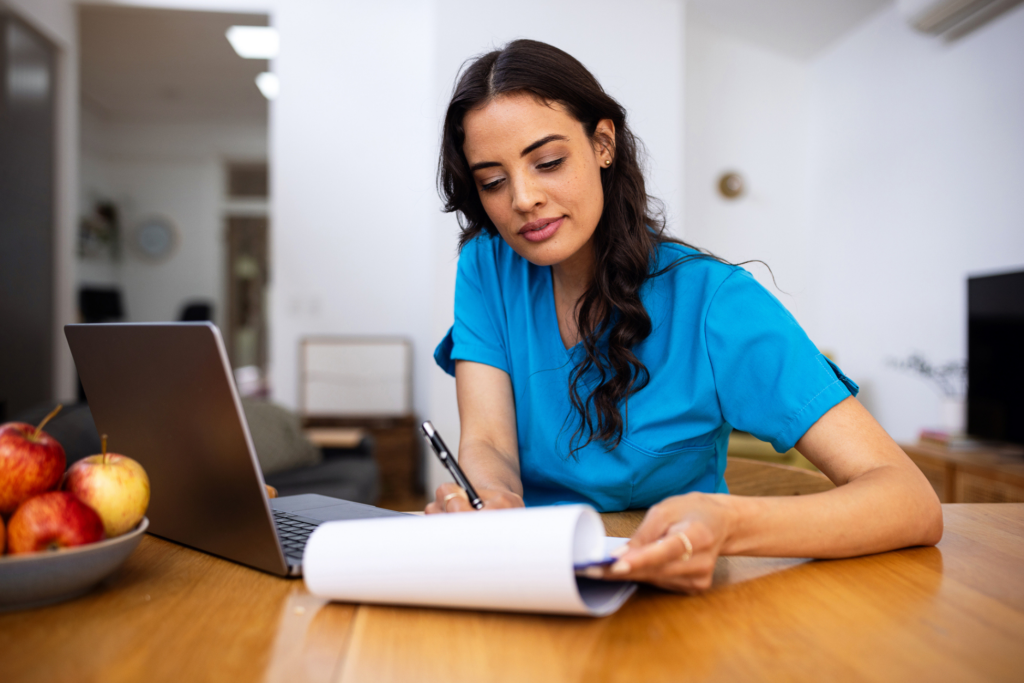 Nurse sits at her desk and writes notes