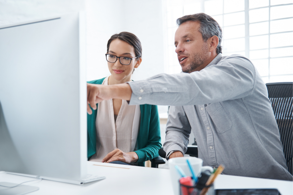 Shot of two colleagues working on a computer at a desk in an office