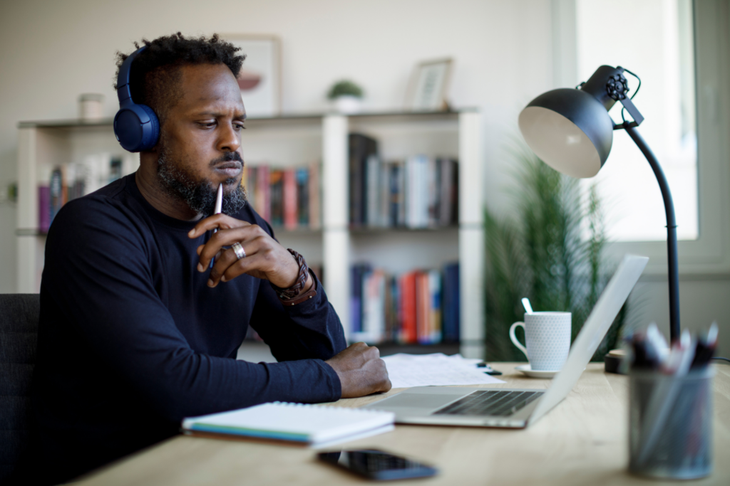 Worried man with headphones taking online course seminar, watching webinar