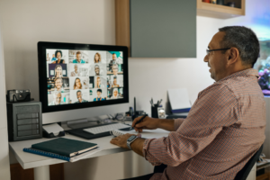Businessman working with colleague through video conferencing from his home