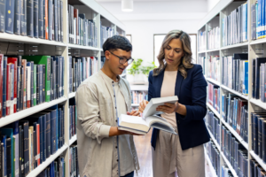 Teacher helping a college searching for a book at the library