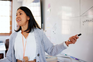 Teacher, whiteboard and pointing in classroom