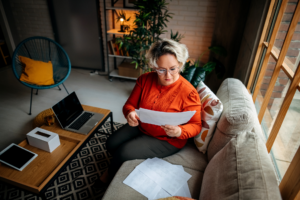 Business woman in her living room on the sofa examines the papers