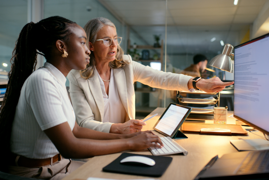 Business, people and computer with training in office to prepare accounting reports and finance filing system. Mentor, mature manager and helping intern accountant to track financial payments at desk