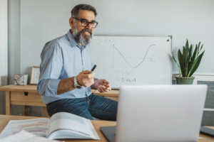Mature man at home teaching students online