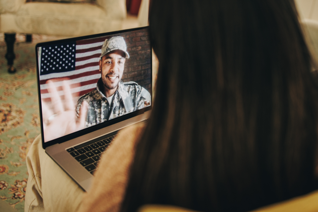 American soldier video calling his family during the holidays. Serviceman communicating with his family on a laptop. Military family having an online holiday celebration.