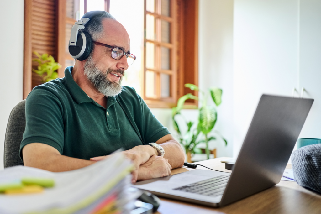 Mature man having video call on laptop at home office