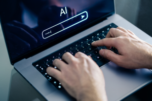Man using chatbot with laptop at work. Creative content