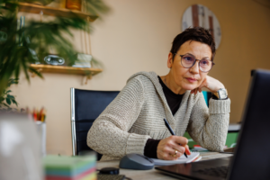 Experienced woman in her fifties working alone in home office