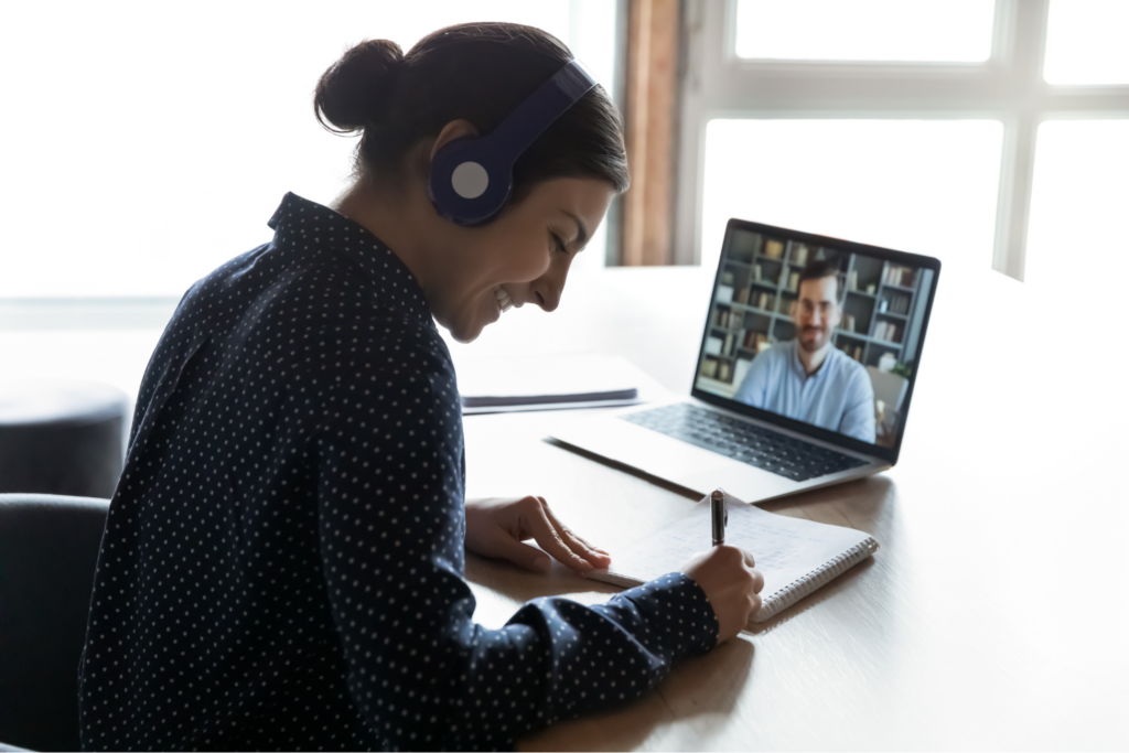Smiling young indian woman in headphones learning practicing foreign language with confident male tutor distantly on computer.