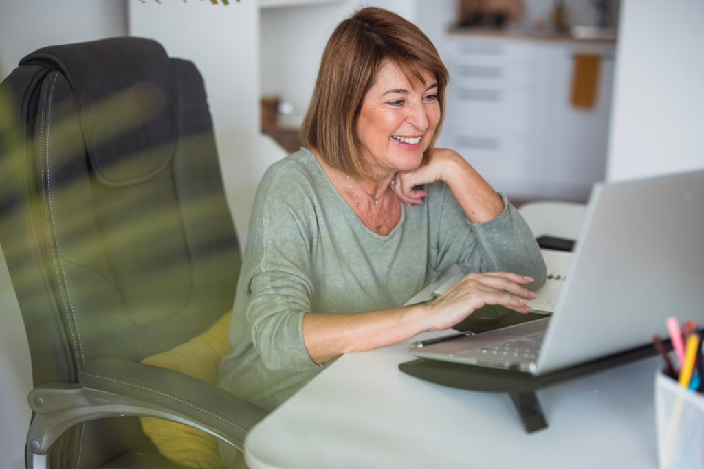 Cheerful mature businesswoman using a laptop and smiling