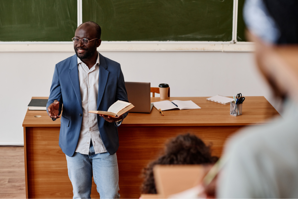 teacher standing with book and reading lecture for students at university