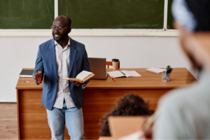 teacher standing with book and reading lecture for students at university